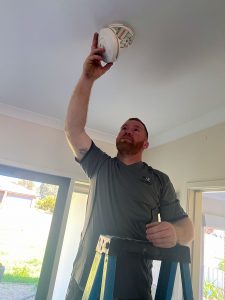 electrician installing smoke alarm